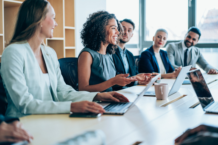 Office meeting with multiple people around a table