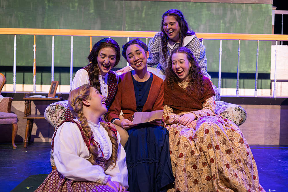 five women in costume on stage