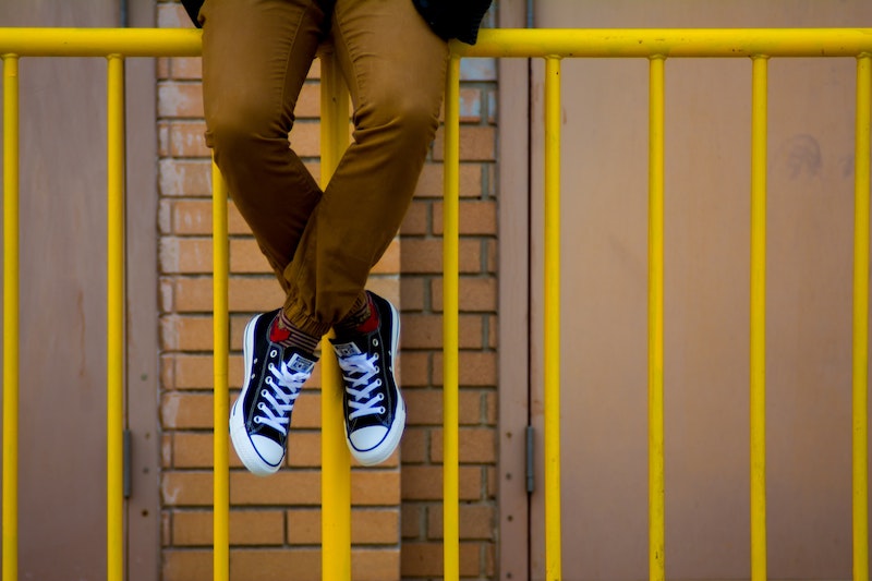 student sitting on fence