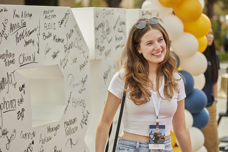 Female students standing in front of signed CBU letter sculpture