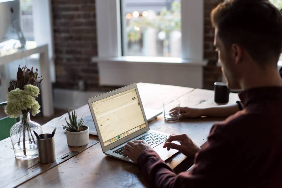 A man typing on a laptop at a desk