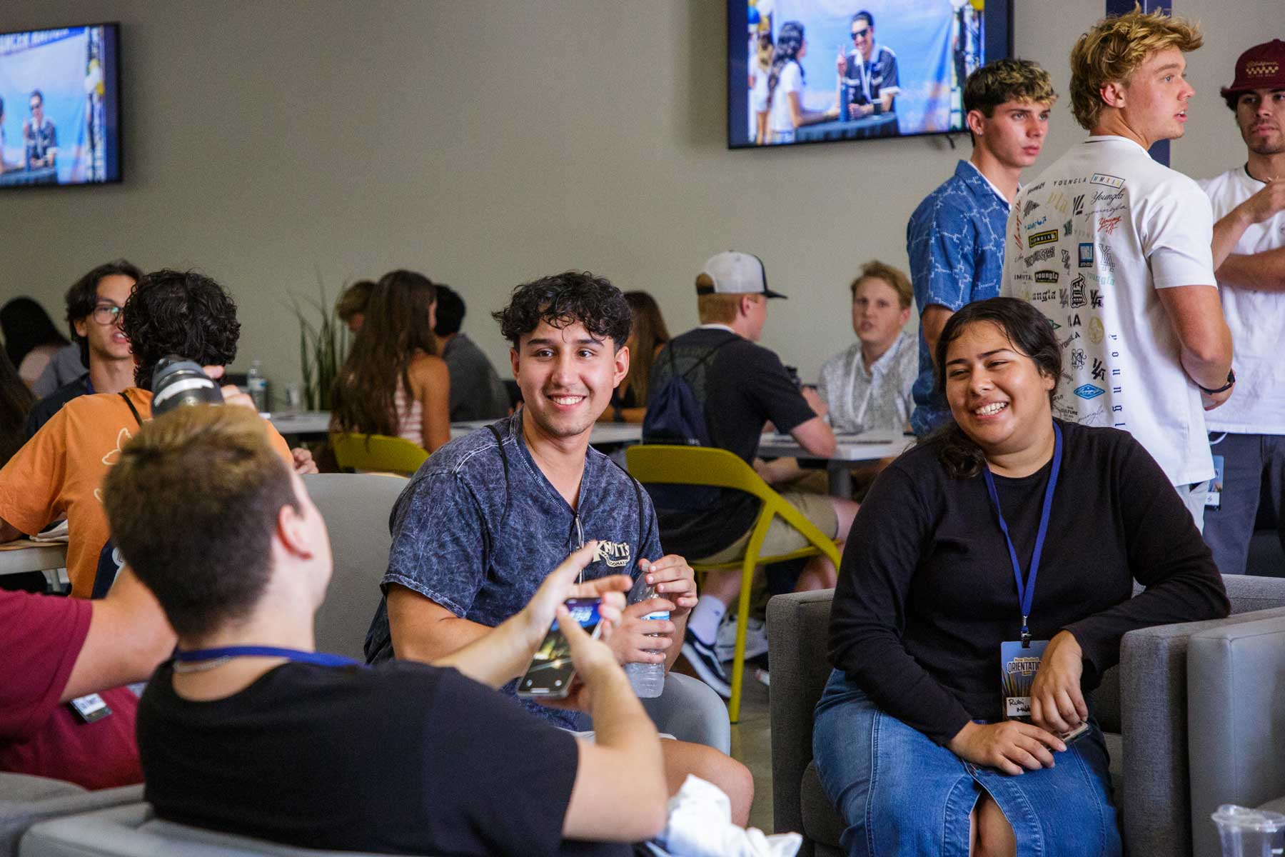 Students talking in a lounge, one has a water bottle